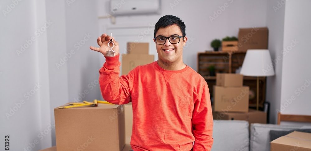 Young man showing us the key to his new home